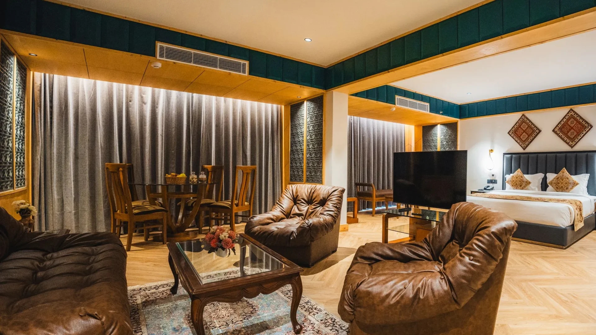 Boutique Suite with king bed, leather sofas and a dining area