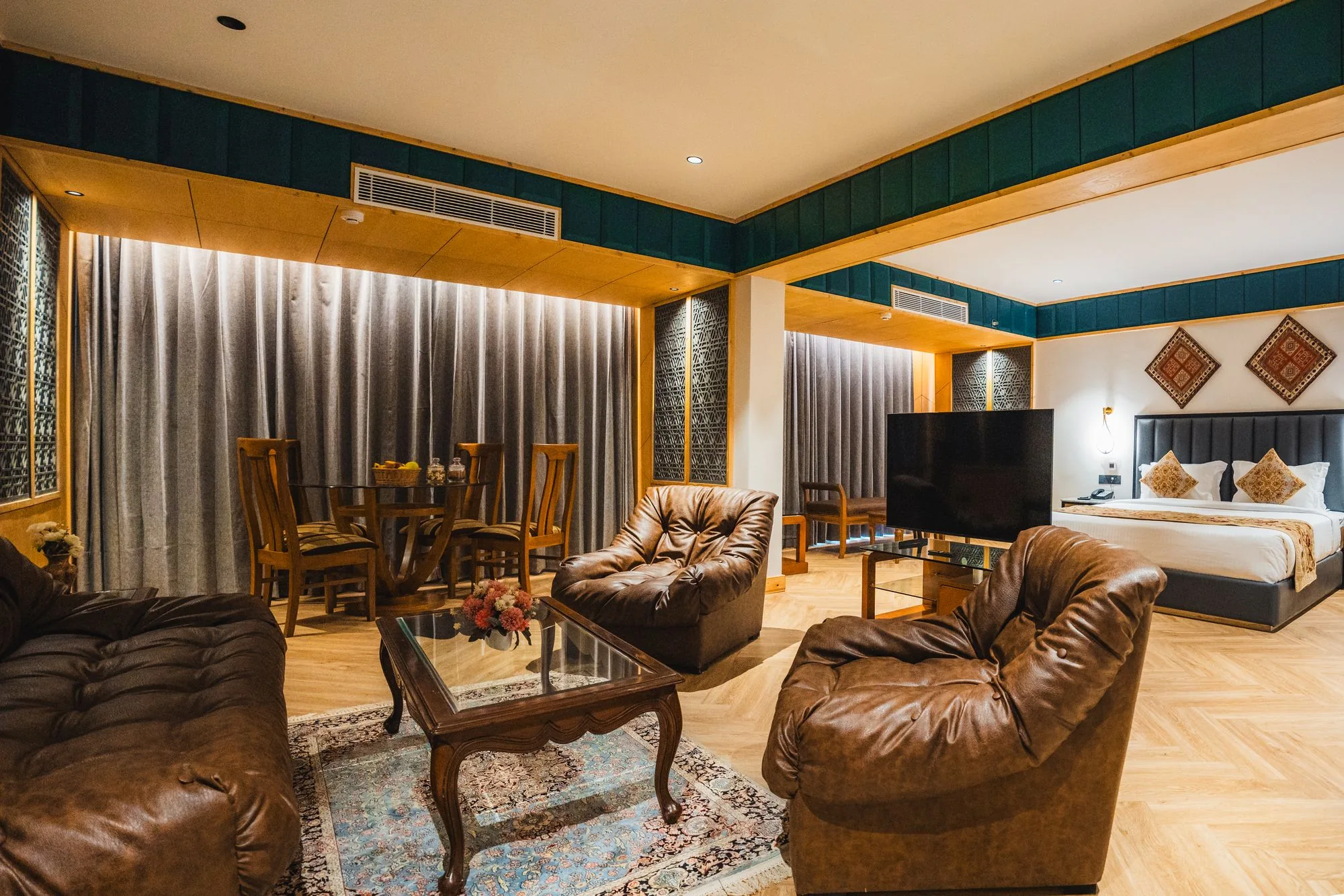 Boutique Suite with king bed, leather sofas and a dining area