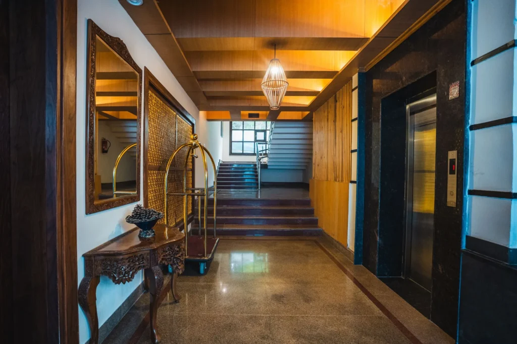Corridor with a wooden staircase and lift lobby at Wisaal Srinagar