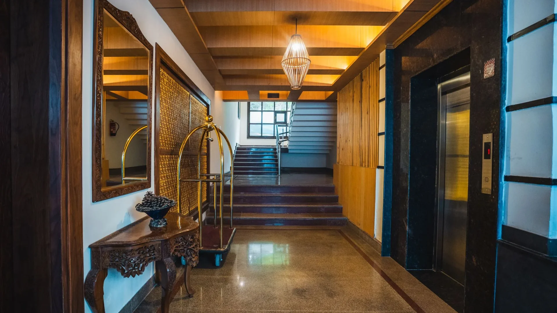 Corridor with a wooden staircase and lift lobby at Wisaal Srinagar