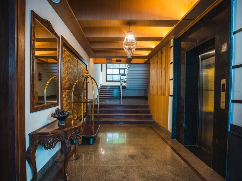 Corridor with a wooden staircase and lift lobby at Wisaal Srinagar