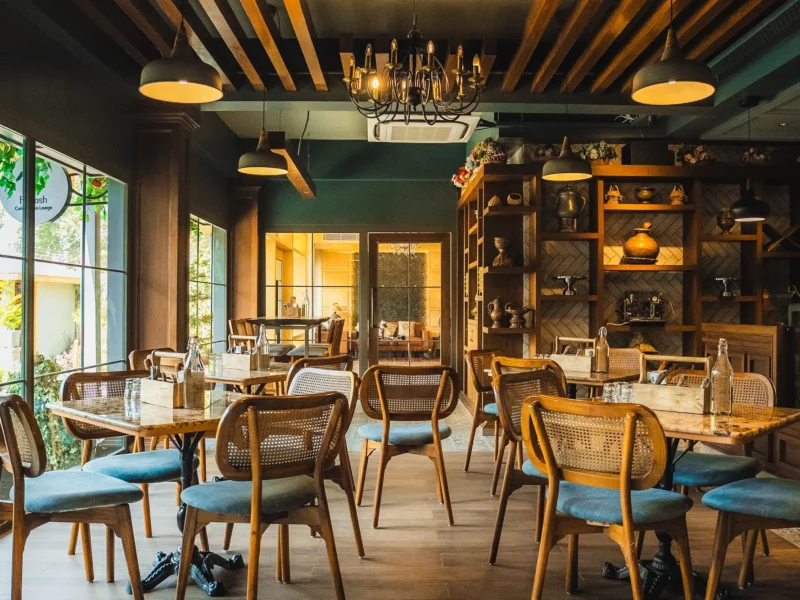 Fatoosh Café with wooden shelves, chandeliers and tables laid for guests