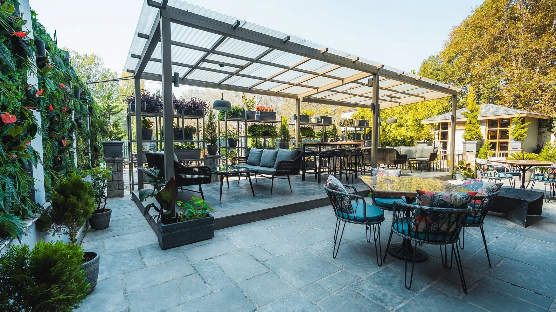 Covered outdoor seating area with plants at Fatoosh Café